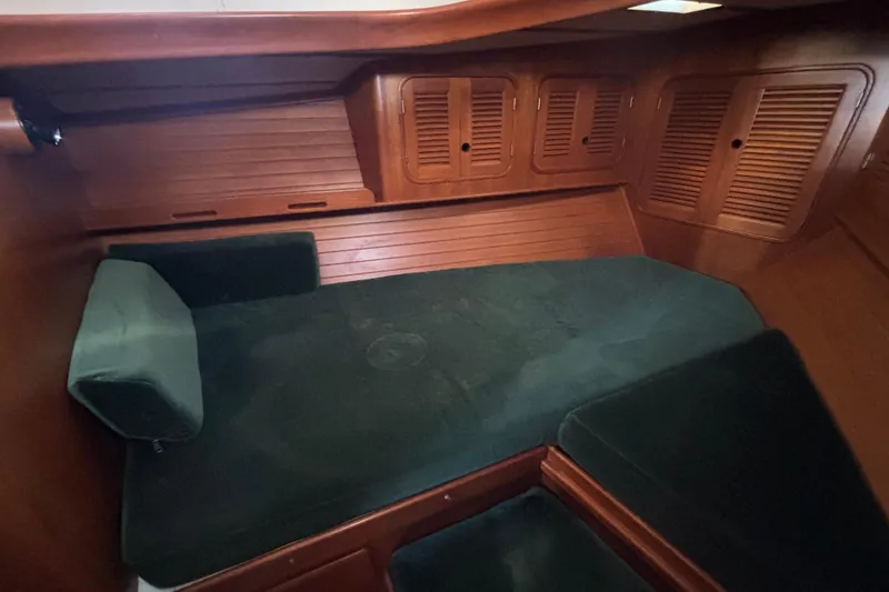 Slide: The Image of 1985 Mason 33 sailboat cockpit with wooden trim, steering wheel, and marina view. - 13