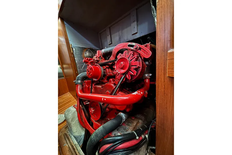 Slide: The Image of Red engine inside a 1985 Mason 33 boat, showcasing detailed mechanical components. - 26