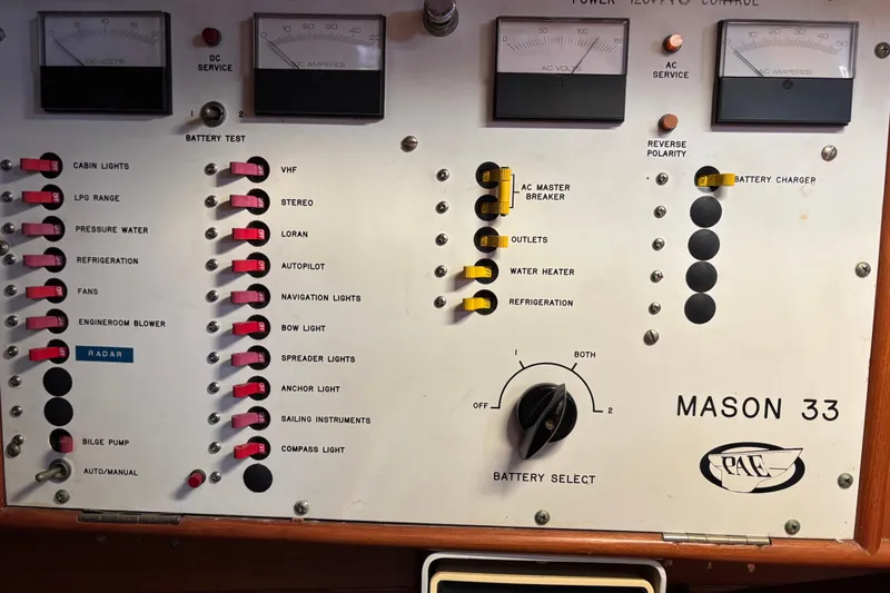 Slide: The Image of Electrical control panel of a 1985 Mason 33 boat with various switches and gauges. - 27