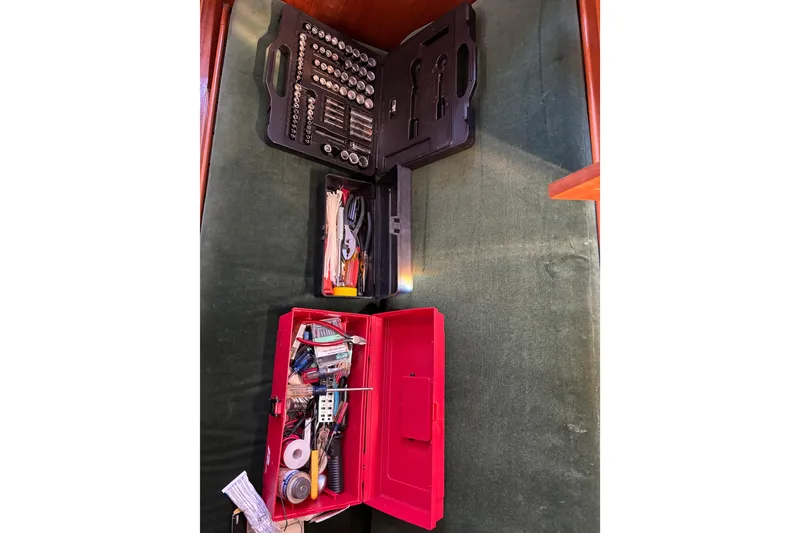 Slide: The Image of Open toolboxes with assorted tools on a green surface, Mason 33, 1985. - 29