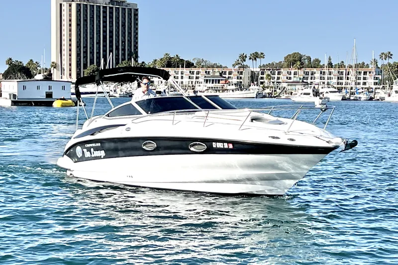 The Image of 2004 Crownline 250 CR boat cruising in a marina with buildings in the background. - 0