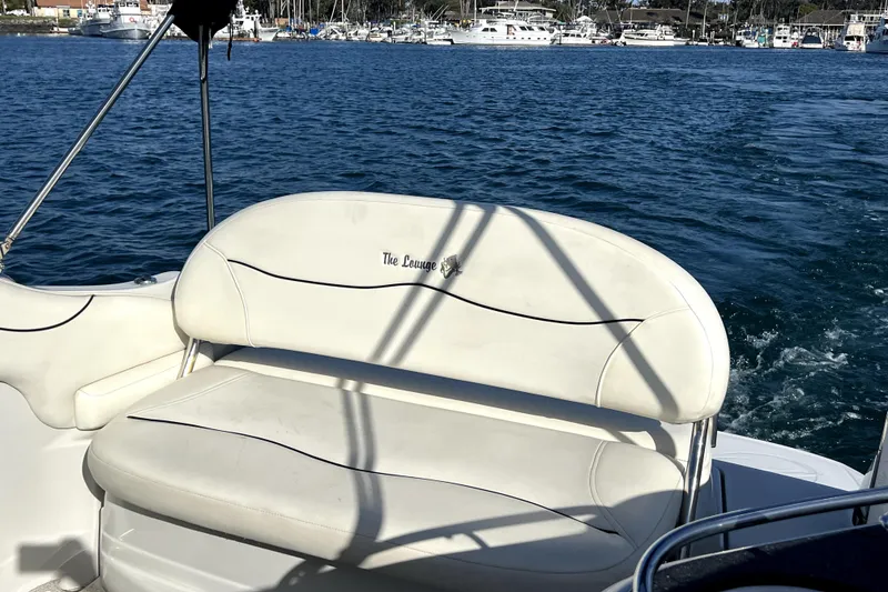 Slide: The Image of 2004 Crownline 250 CR boat with white seating, docked in a marina. - 10