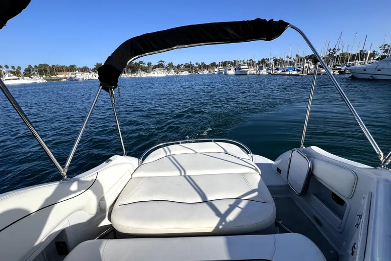 Slide: The Image of 2004 Crownline 250 CR boat interior with marina view, clear blue sky, and calm waters. - 12