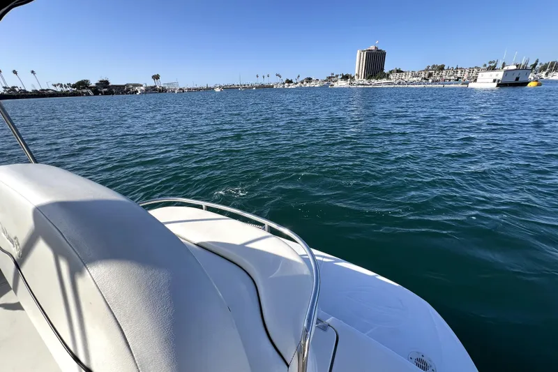 Slide: The Image of 2004 Crownline 250 CR boat on calm water with cityscape in background. - 13