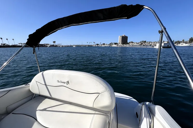 Slide: The Image of 2004 Crownline 250 CR boat on water, cityscape in background, sunny day. - 14