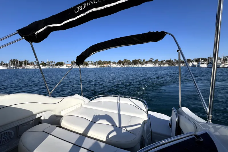 Slide: The Image of 2004 Crownline 250 CR boat on calm water with scenic marina view. - 15
