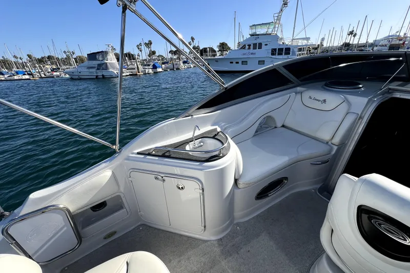 Slide: The Image of 2004 Crownline 250 CR boat interior with seating and sink, docked at marina. - 17