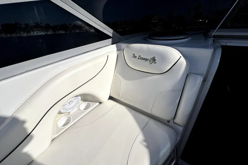Slide: The Image of Luxurious seating on 2004 Crownline 250 CR boat, featuring "The Lounge" embroidery and cup holders. - 18