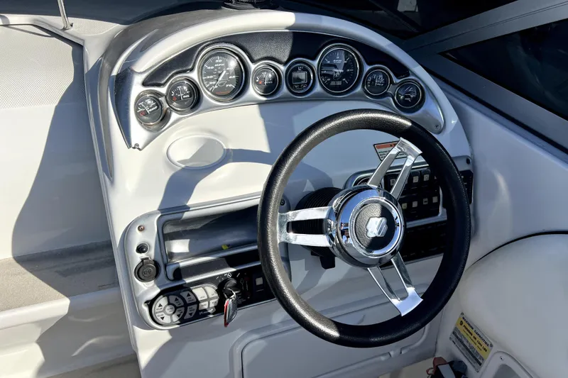 Slide: The Image of Dashboard of a 2004 Crownline 250 CR boat with steering wheel and gauges. - 19