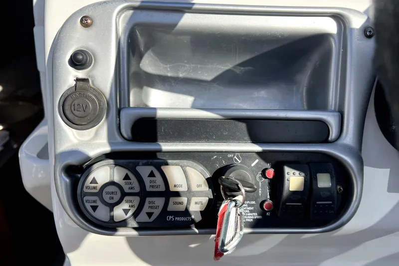 Slide: The Image of Control panel of a 2004 Crownline 250 CR boat with ignition and audio controls. - 23