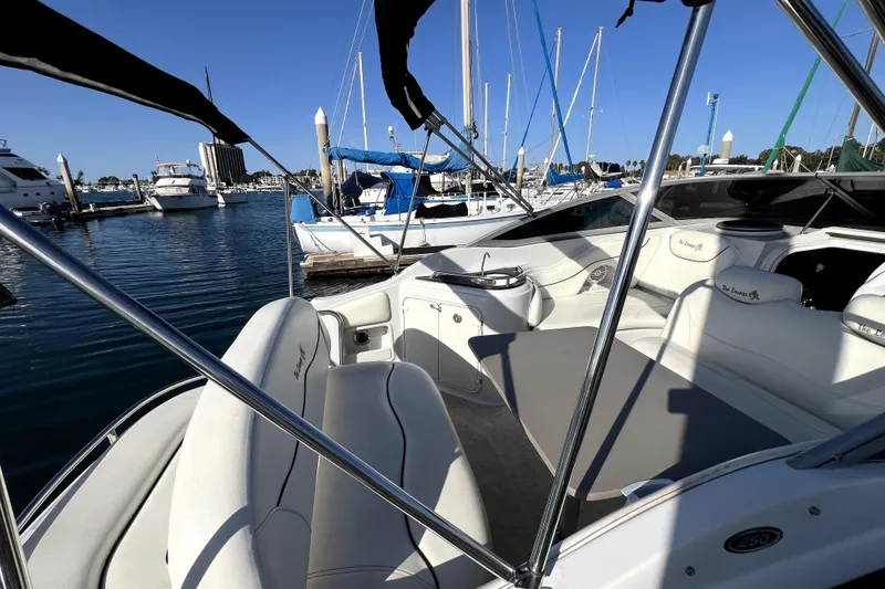 Slide: The Image of 2004 Crownline 250 CR boat interior at marina, featuring white seating and sleek design. - 25