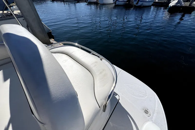 Slide: The Image of 2004 Crownline 250 CR boat with white seating, docked at a marina. - 28