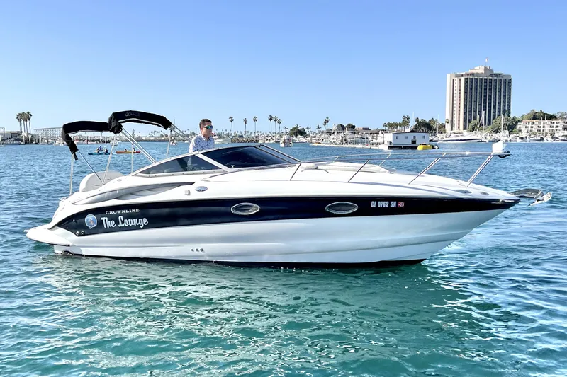 Slide: The Image of 2004 Crownline 250 CR boat on water, sunny day, cityscape background. - 3