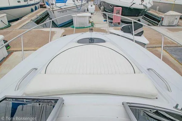 Slide: The Image of 2004 Crownline 250 CR boat docked, featuring a spacious sunpad and sleek design. - 30