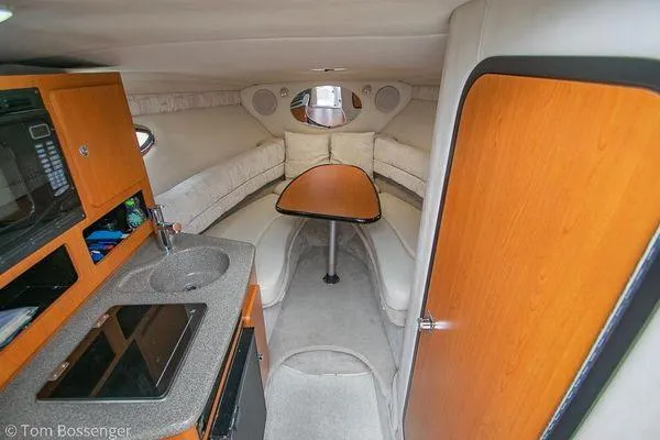 Slide: The Image of 2004 Crownline 250 CR cabin interior with kitchenette, seating, and table. - 39
