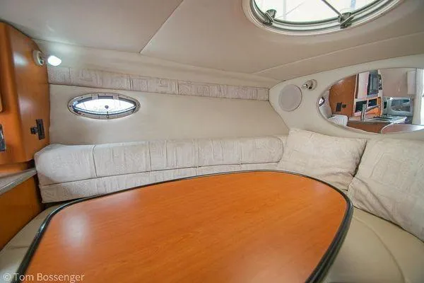 Slide: The Image of Interior of 2004 Crownline 250 CR boat with cozy seating and wooden table. - 41