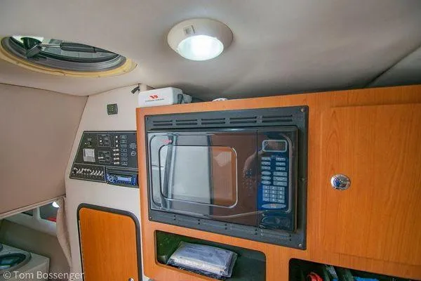Slide: The Image of Interior of 2004 Crownline 250 CR boat with microwave and control panel. - 44