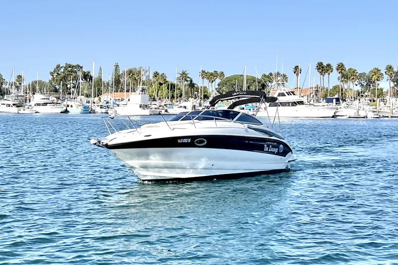 Slide: The Image of 2004 Crownline 250 CR boat cruising in a marina with palm trees and yachts. - 5