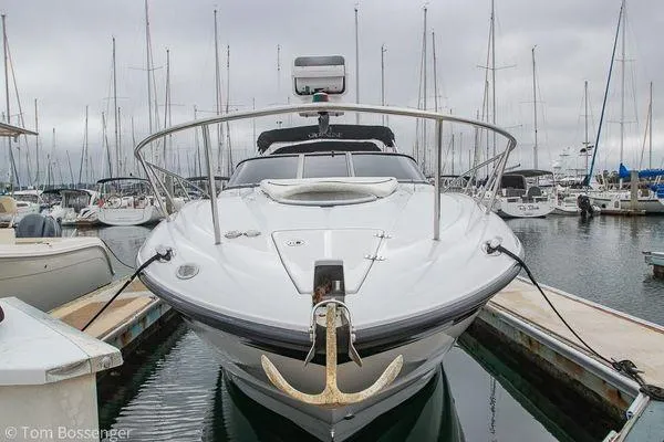 Slide: The Image of 2004 Crownline 250 CR boat docked in a marina, surrounded by sailboats. - 55