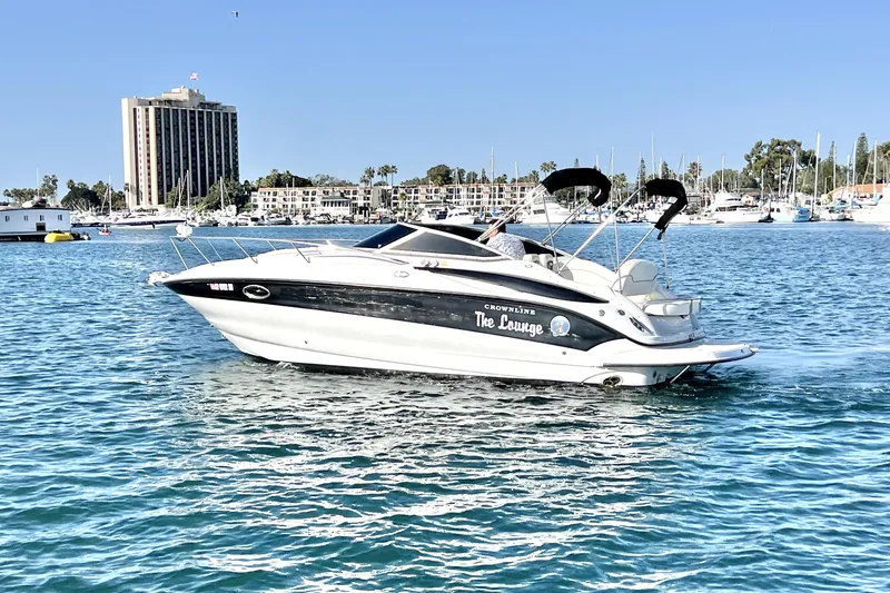 Slide: The Image of 2004 Crownline 250 CR boat on water, cityscape background, clear blue sky. - 6