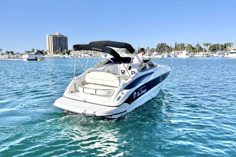 Slide: The Image of 2004 Crownline 250 CR boat cruising in a marina with clear blue water. - 8