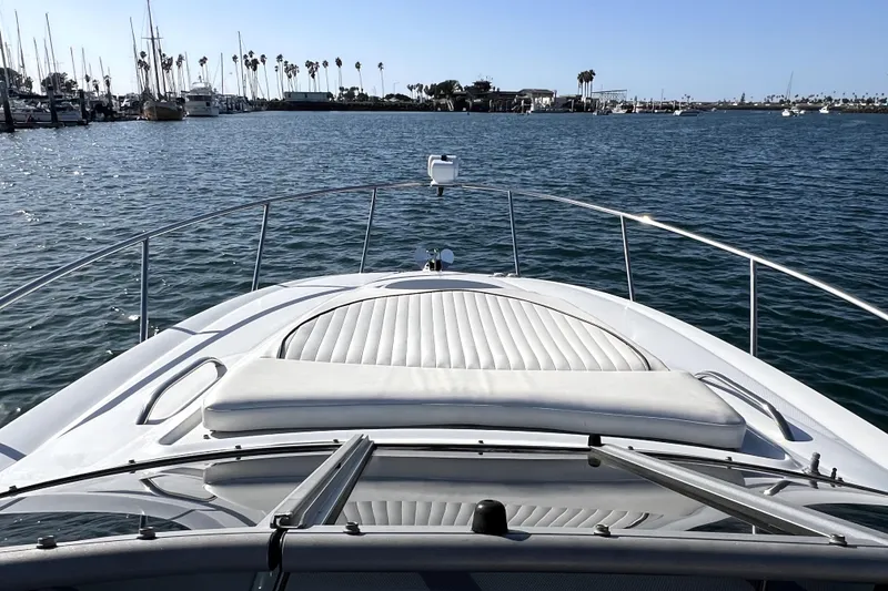 Slide: The Image of 2004 Crownline 250 CR boat on calm water, marina view in background. - 9
