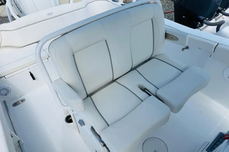 Slide: The Image of 2023 Sea Hunt Ultra 255 SE boat interior with white cushioned seating. - 10