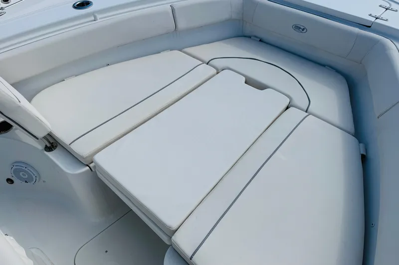 Slide: The Image of 2023 Sea Hunt Ultra 255 SE boat interior with cushioned seating area. - 11