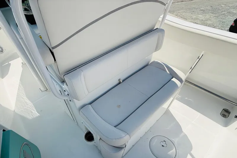 Slide: The Image of 2023 Sea Hunt Ultra 255 SE boat interior seating, featuring white cushioned bench. - 15