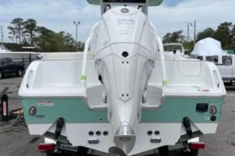 Slide: The Image of 2023 Sea Hunt Ultra 255 SE boat with powerful outboard motor, parked outdoors. - 2