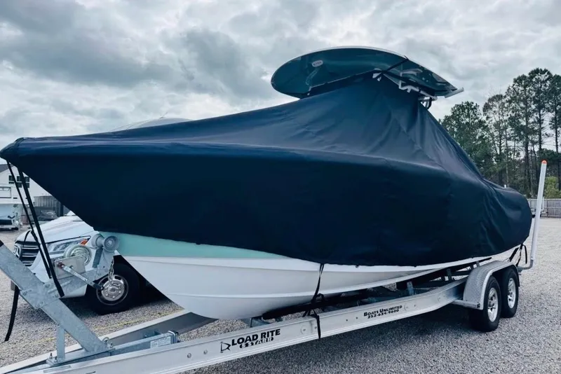 Slide: The Image of 2023 Sea Hunt Ultra 255 SE boat covered on trailer, cloudy sky background. - 7