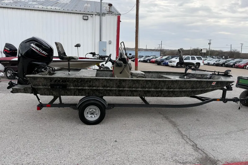 Slide: The Image of 2025 Tracker Grizzly 1860 MVX CC boat interior with camouflage seating and control console. - 18