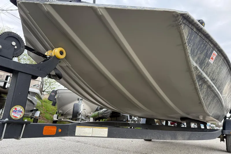 Slide: The Image of 2025 Tracker Grizzly 1860 MVX CC boat with camo design and trailer. - 24