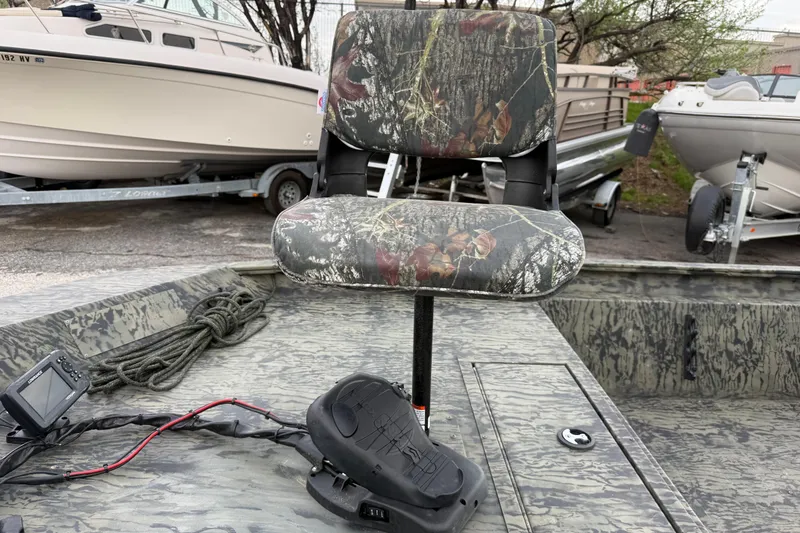 Slide: The Image of 2025 Tracker Grizzly 1860 MVX CC boat with camouflage design and engine details. - 28