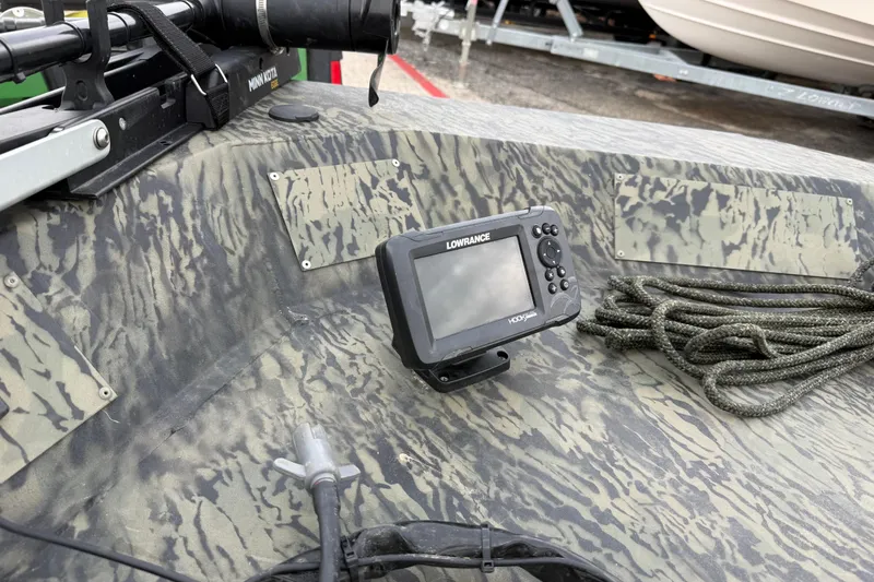 Slide: The Image of 2025 Tracker Grizzly 1860 MVX CC boat on trailer, featuring camouflage design and outboard motor. - 29