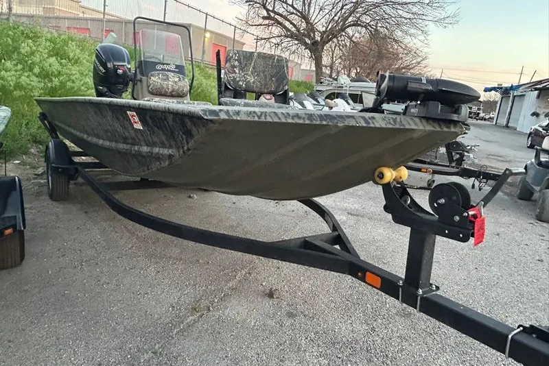 Slide: The Image of 2025 Tracker Grizzly 1860 MVX CC boat with Mercury outboard motor in a parking lot. - 5