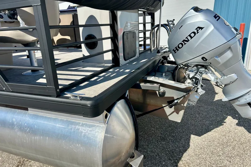 Slide: The Image of 2023 Flagship 200 Lounge Lounger with Honda outboard motor, docked on pavement. - 14