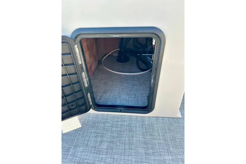 Slide: The Image of Open storage compartment in 2023 Flagship 200 Lounge Lounger boat, showing interior details. - 36