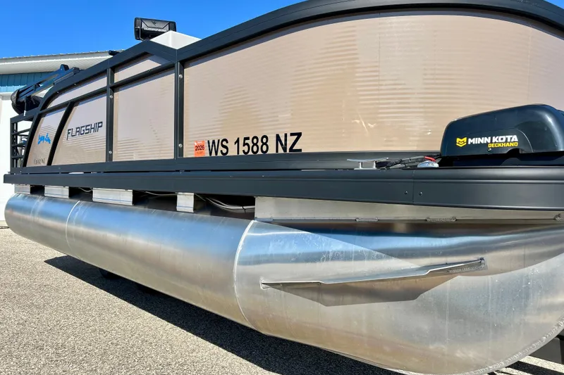 Slide: The Image of 2023 Flagship 200 Lounge Lounger pontoon boat with Minn Kota motor, docked outdoors. - 4