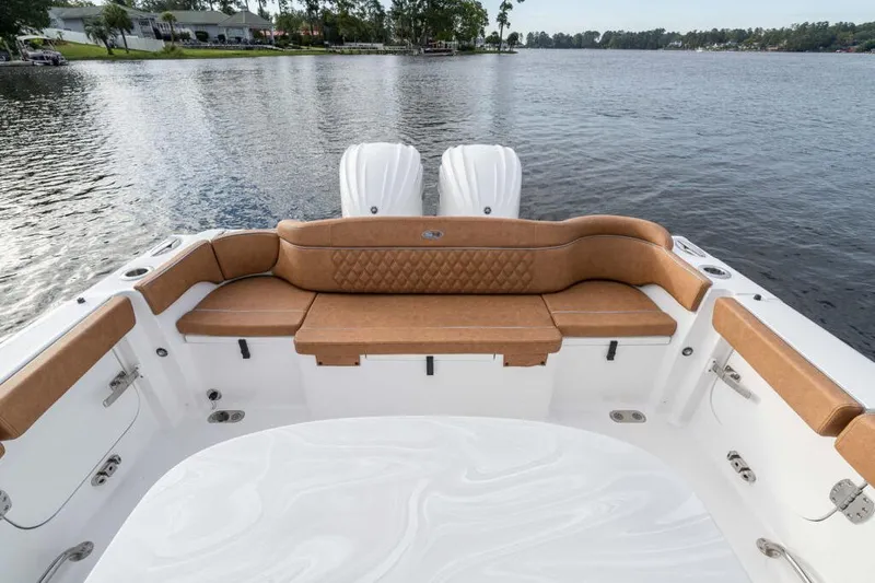 Slide: The Image of Manufacturer Provided Image: 2026 Sea Hunt Ultra 285 SE boat interior with tan seating, overlooking serene lake. - 7