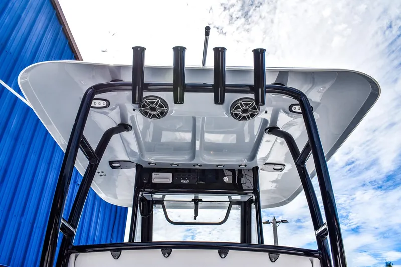 Slide: The Image of 2026 Sea Hunt Ultra 285 Coffin Box boat with T-top and rod holders against blue sky. - 5