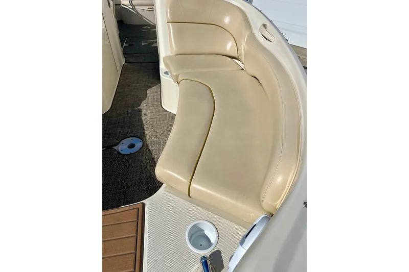 Slide: The Image of 2000 Sea Ray 240 Sundeck interior with beige seating and carpeted floor. - 15