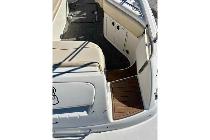 Slide: The Image of 2000 Sea Ray 240 Sundeck boat interior with beige seating and cup holder. - 16