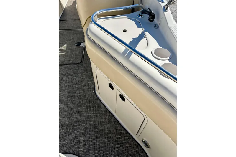 Slide: The Image of Interior of 2000 Sea Ray 240 Sundeck boat with beige seating and logo. - 18