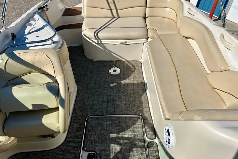 Slide: The Image of 2000 Sea Ray 240 Sundeck interior with beige seating and carpeted floor. - 23