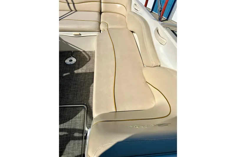 Slide: The Image of Interior of 2000 Sea Ray 240 Sundeck boat with beige seating and carpet flooring. - 24