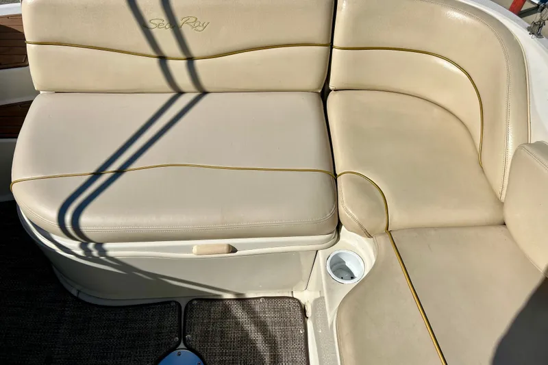 Slide: The Image of 2000 Sea Ray 240 Sundeck interior with beige seating and carpeted flooring. - 25