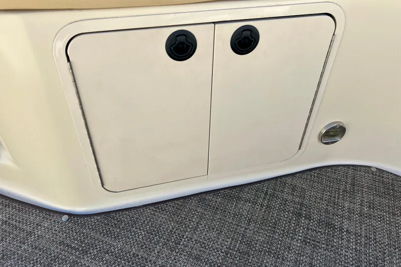 Slide: The Image of Interior of a 2000 Sea Ray 240 Sundeck boat with beige seating and storage compartment. - 41