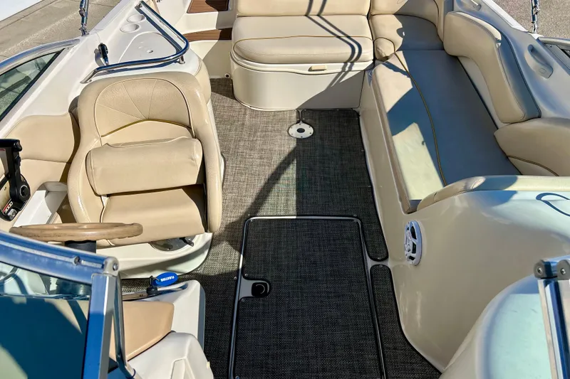Slide: The Image of 2000 Sea Ray 240 Sundeck interior with beige seating and carpeted floor. - 50