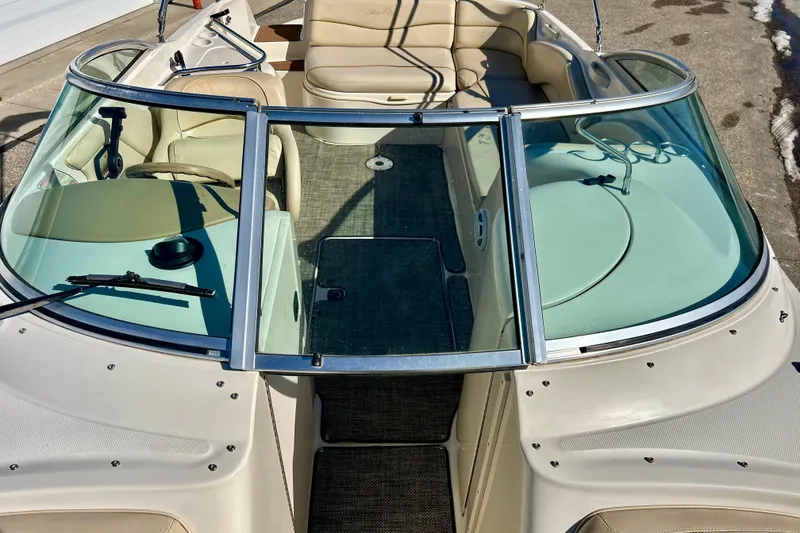 Slide: The Image of 2000 Sea Ray 240 Sundeck boat with windshield and seating, docked outdoors. - 52